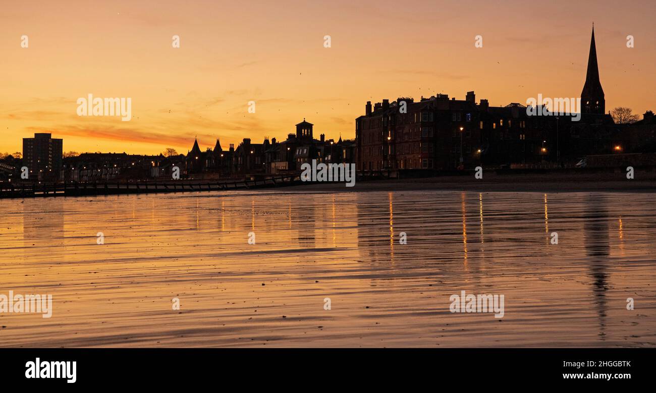 Portobello Beach, Edinburgh, Schottland, Großbritannien. 21st. Januar 2022. Eisiger Freitag bei Sonnenaufgang mit kühler Windchill und einer Temperatur von 3 Grad Celsius. Im Bild: Malerischer Blick in der Silhouette eines ruhigen Sandstrands bei Sonnenaufgang, der sich im nassen Sand widerspiegelt. Kredit: Archwhite/alamy Live Nachrichten. Stockfoto