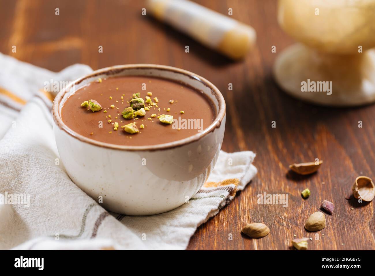 Pudding aus Vanille und Schokolade mit Schokoladenbröseln, Sternanise. Platziert auf weißem rustikalem Brett. Stockfoto