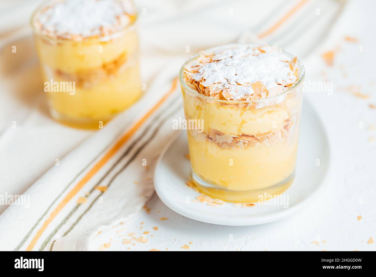 Vanillepudding Dessert namens Krempita serviert auf unterschiedliche Weise in einem Glas auf einem hellen Hintergrund Stockfoto