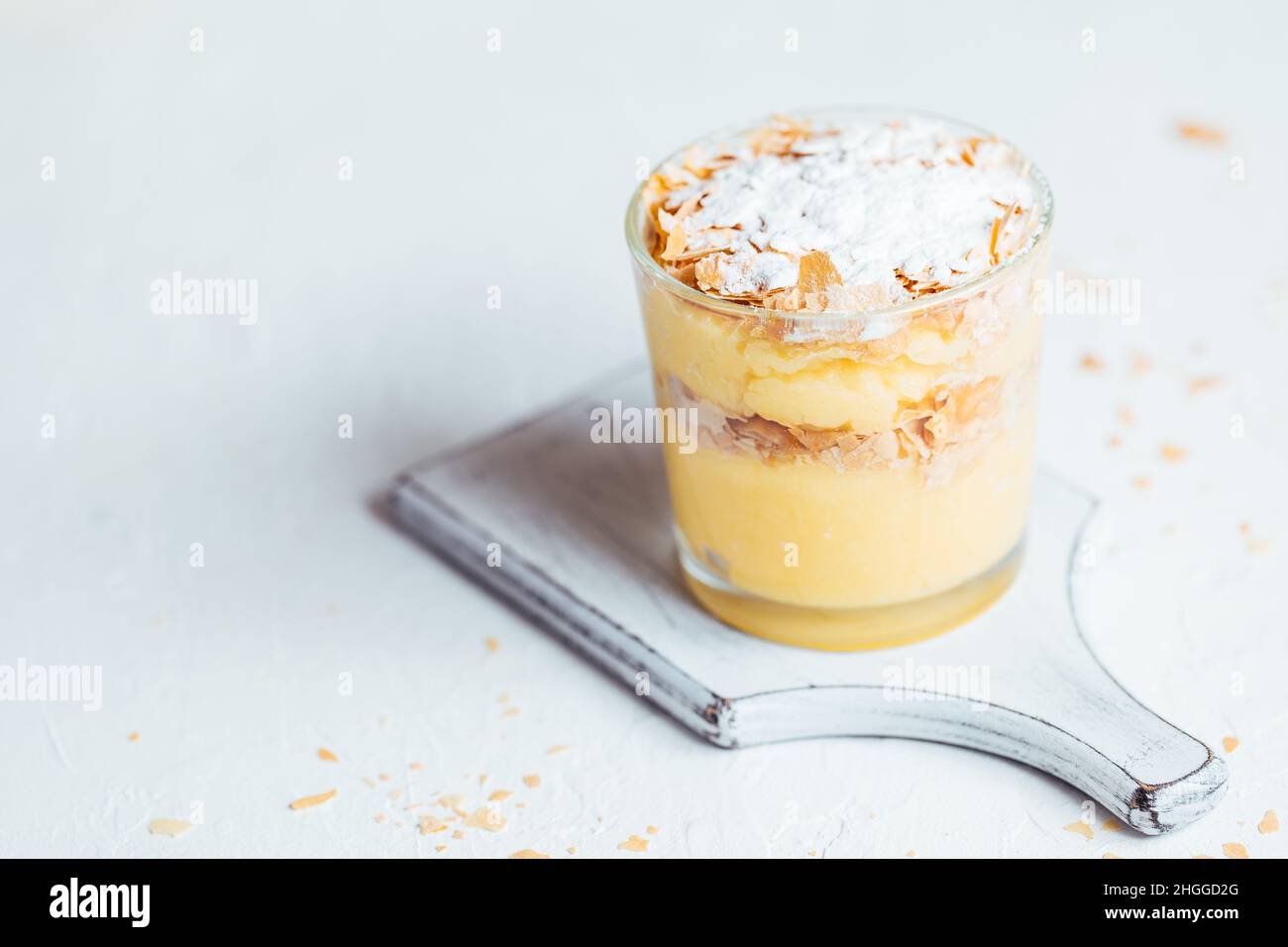 Vanillepudding Dessert namens Krempita serviert auf unterschiedliche Weise in einem Glas auf einem hellen Hintergrund Stockfoto