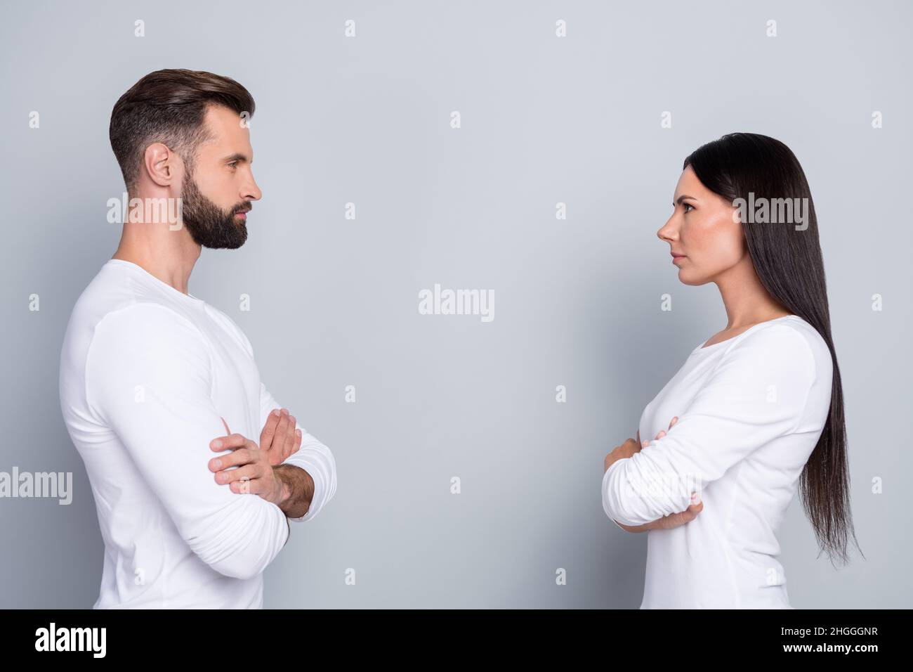 Foto von attraktiven zuversichtlich Schwester Bruder tragen weiße Hemden Hände gekreuzt suchen einander isoliert graue Farbe Hintergrund Stockfoto