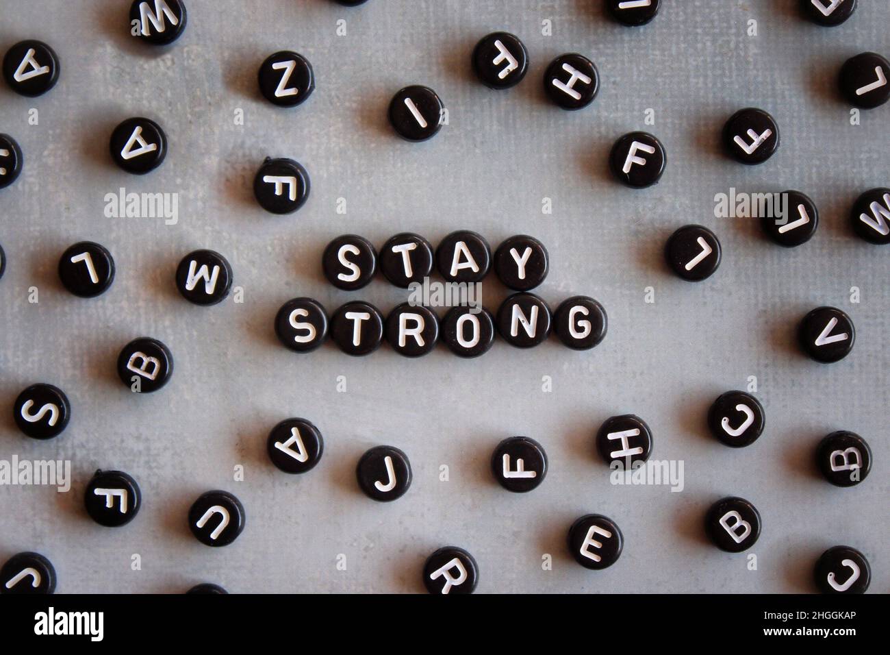 Selektives Fokusbild von Alphabetisphären mit Text BLEIBT AUF Betonboden stabil. Stockfoto