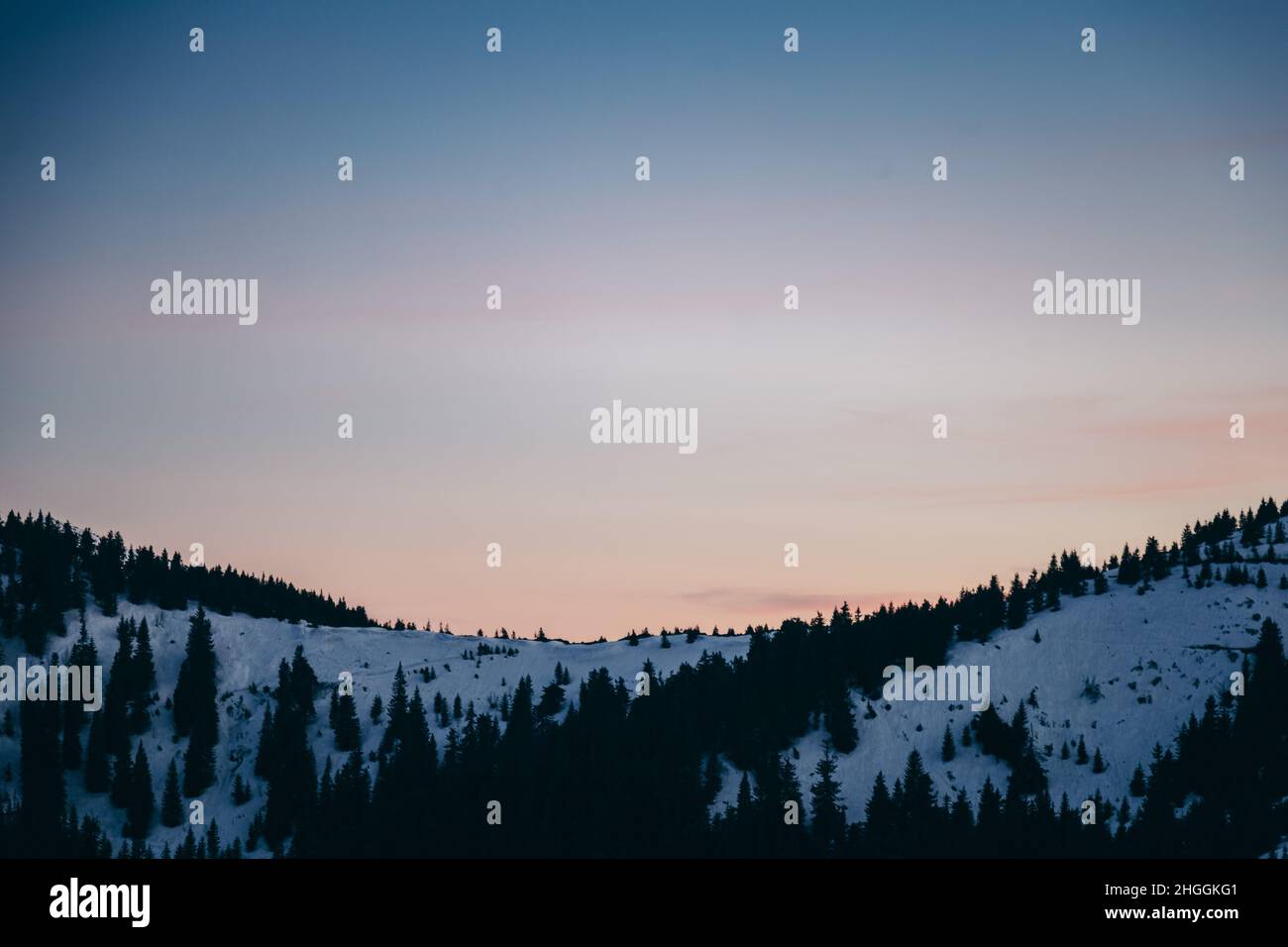 Verschneite Wiese, verschneite Berge und Sterne im Hintergrund Stockfoto