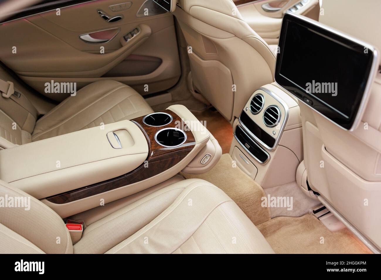 Die Rücksitze des Luxuswagens in Echtholz und Leder sowie der Multimedia-Bildschirm Stockfoto