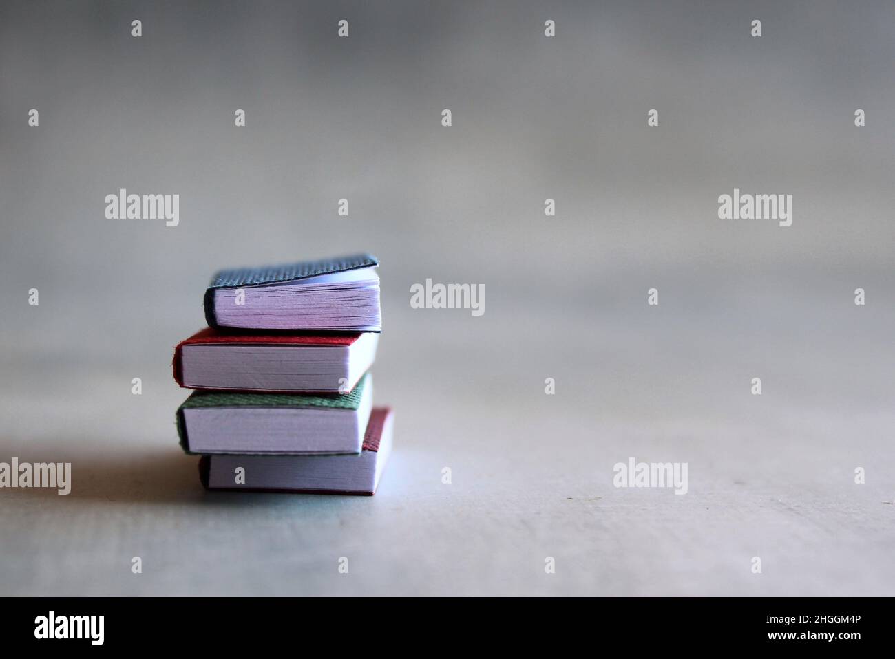 Selektiver Bildstapel mit Büchern auf Betonboden mit Platz für Text Stockfoto