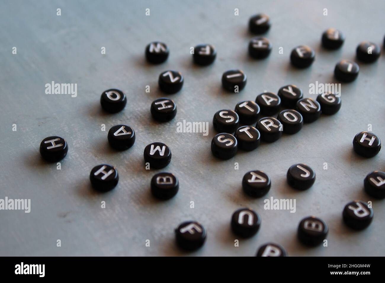 Selektives Fokusbild von Alphabetisphären mit Text BLEIBT AUF Betonboden stabil. Stockfoto