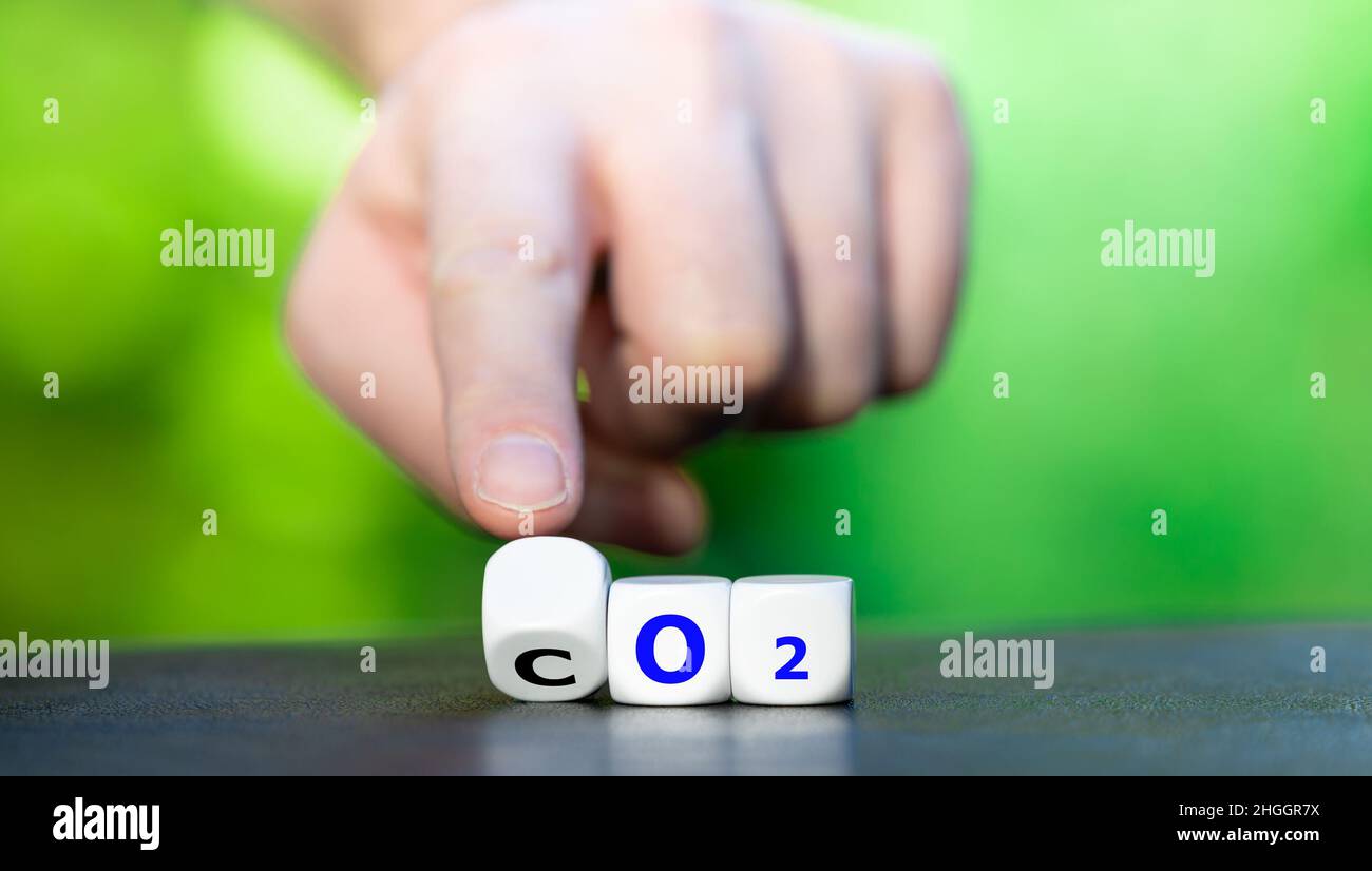 Symbol für die Reduzierung von CO2. Hand dreht Würfel und ändert den Ausdruck 'CO2' in 'O2'. Stockfoto