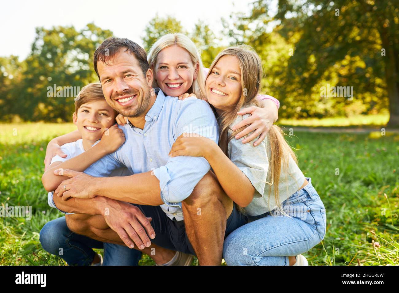 Glückliche Eltern und zwei Kinder als harmonische Familie im Sommerurlaub in der Natur Stockfoto