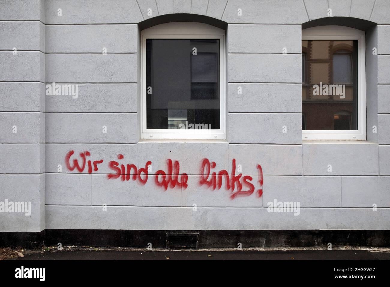 Rote Schrift 'Wir sind alle übrig' auf einem Haus auf der linken Straßenseite, Deutschland, Hessen, Kassel Stockfoto