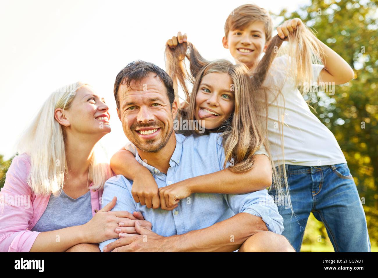 Glückliche Familie im Urlaub und alberne Kinder, die Gesichter machen und Haare ziehen Stockfoto