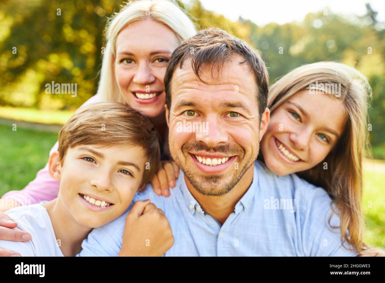 Fröhliche Eltern und zwei Kinder als glückliche Familie im Sommer in der Natur Stockfoto