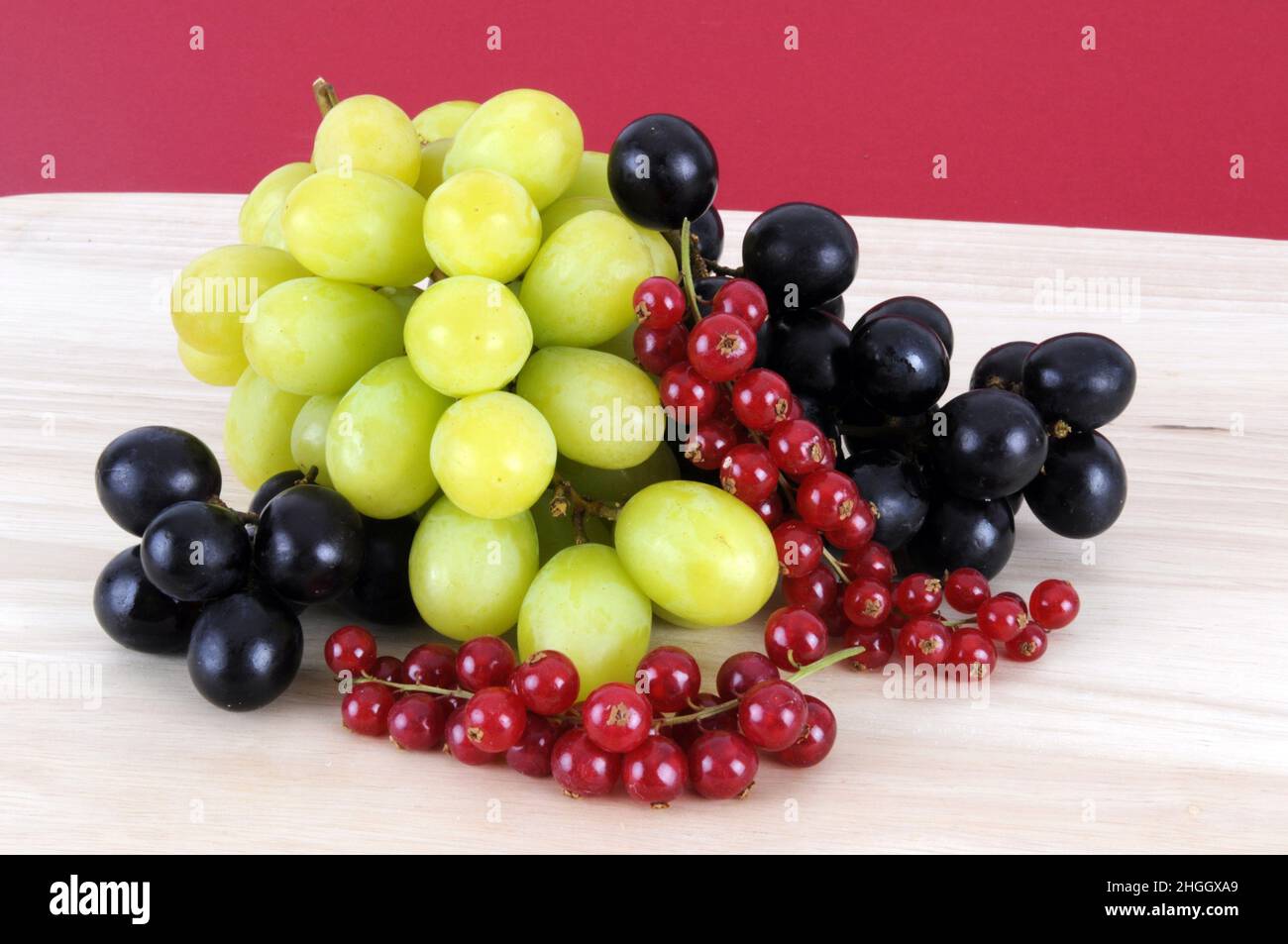 Weinrebe, Weinrebe (Vitis vinifera), rote und grüne Trauben und rote Johannisbeeren Stockfoto