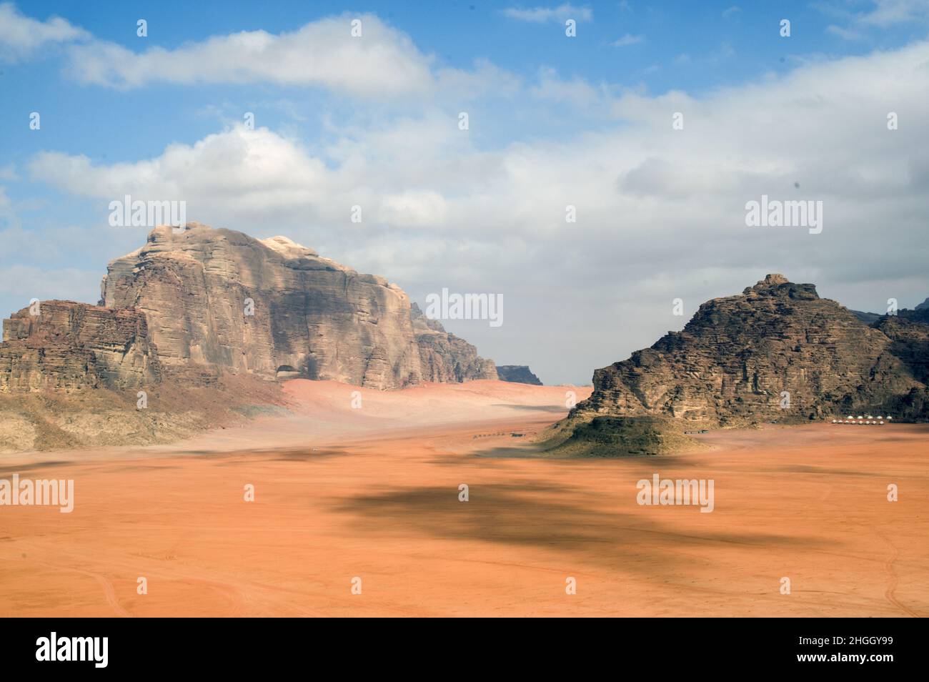 Wüstenlandschaft des Wadi Rum, einer Schlucht in Jordanien mit rotem Sand und Felswänden. Stockfoto