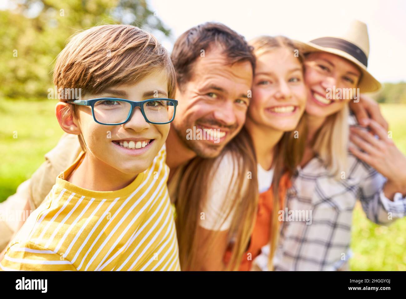 Glücklicher Junge mit Eltern und Schwester als harmonische kleine Familie in der Natur Stockfoto