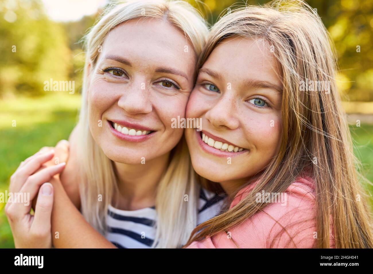 Die glückliche Tochter umarmt ihre Mutter liebevoll als Symbol für Liebe und Intimität Stockfoto