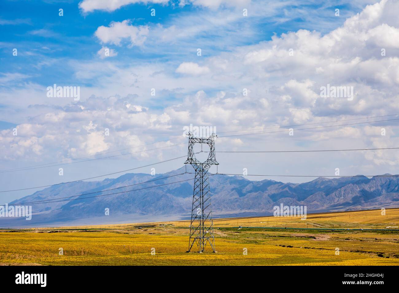 Hochspannungsturm und wunderschöne Berglandschaft in Xinjiang, China. Stockfoto