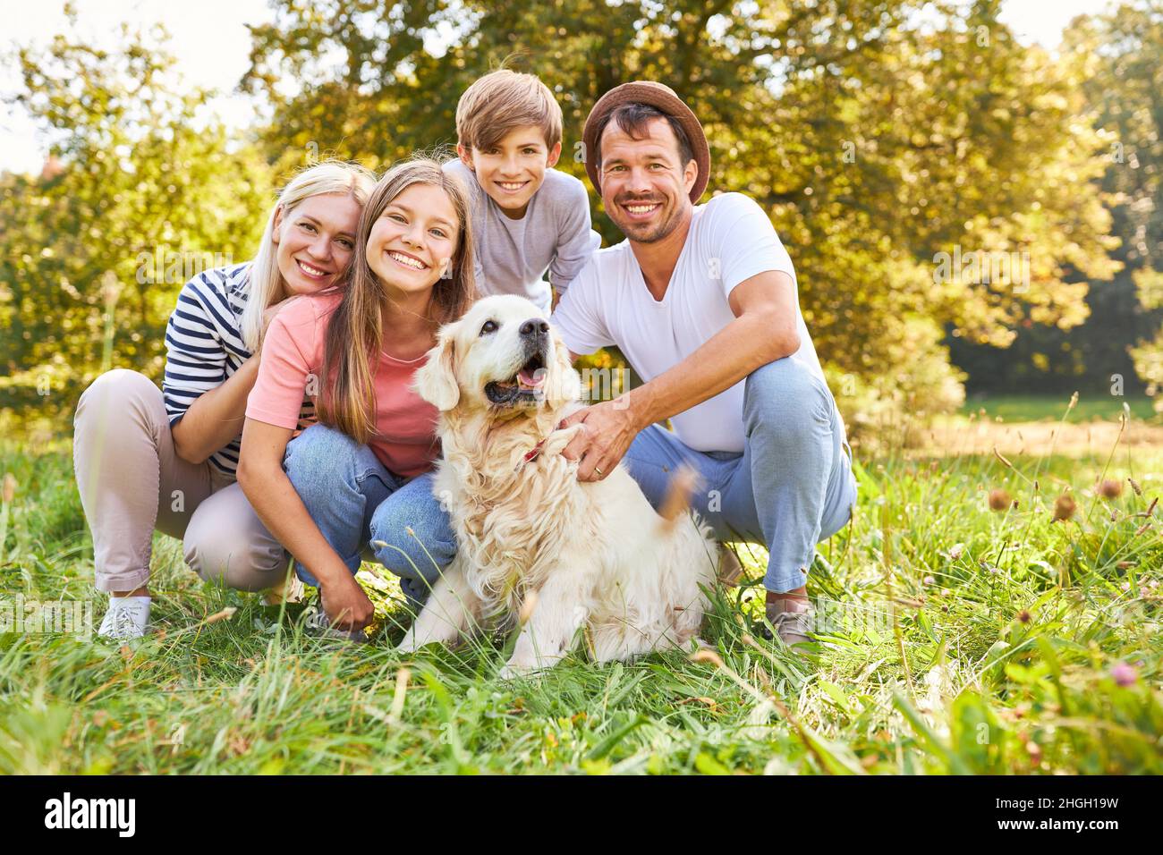 Glückliche Familie mit zwei Kindern und Hund zusammen im Park im Sommer Stockfoto