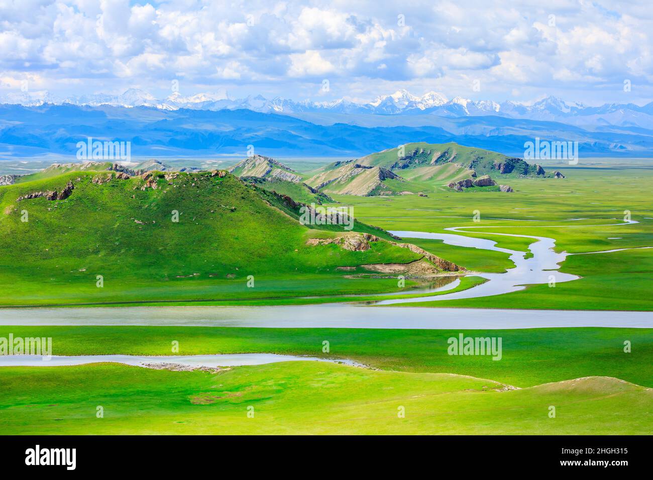 Bayinbuluke Grasland Naturlandschaft in Xinjiang, China.der gewundene Fluss liegt auf dem grünen Grasland. Stockfoto