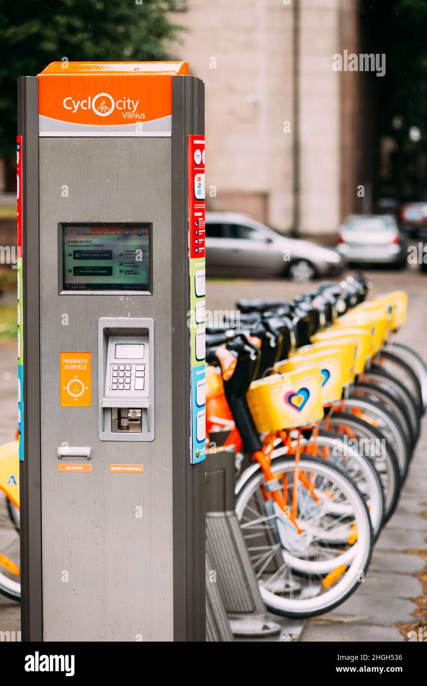 Vilnius, Litauen. Maschine mit elektronischer Zahlung, die eine Genehmigung zum Mieten eines Fahrrads ausstellt. Reihe Von Bunten Fahrrädern Aviva Zu Vermieten Bei Municipal Bike Stockfoto