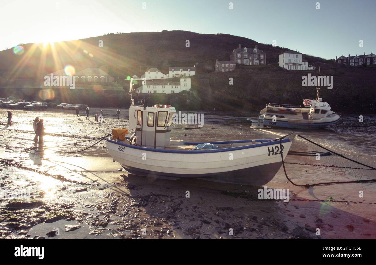 Fischerboote auf der Strandbucht mit der Flut aus dem berühmten Cornish Port Isaac aus dem berühmten Fernsehprogramm von Doc Martin, im Hintergrund sind die Gebäude aus der Fernsehserie zu sehen, Das Dorf heißt in der TV-Comedy-Sendung Portwenn und ist zu einem touristischen Hotspot geworden. Stockfoto
