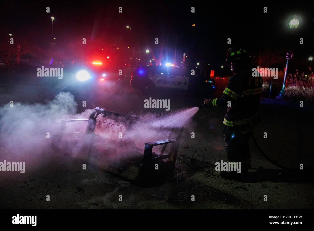 Feuerwehrleute und Polizei reagieren auf ein Sofafeuer der Sample Gates der Indiana University, nachdem das IU-Basketballteam Purdue 68-65 in Bloomington geschlagen hat. Das Feuer wurde ausgelöst, als Fans feierten, die durch die Gegend gingen. Stockfoto