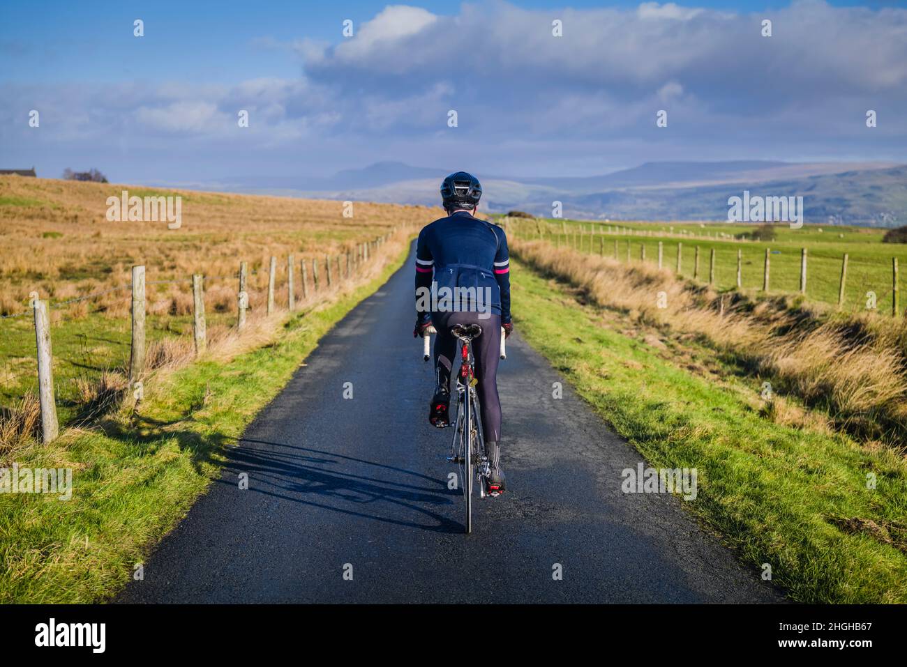 Männlicher Radfahrer auf einspuriger Straße in der Nähe der Grenze des Landkreises Lancashire/Yorkshire, Tosside, Lancashire, Großbritannien. Stockfoto