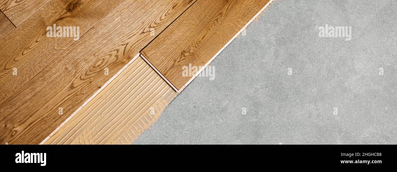 Parkettboden Installation. Holzdielen mit Kleber auf Betonboden. Banner kopieren Raum Stockfoto