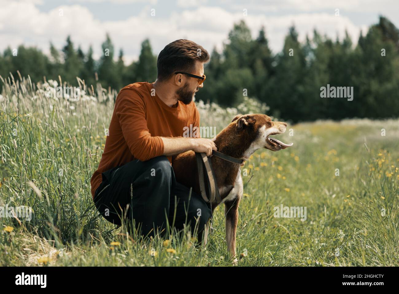 Mann und glücklicher Hund schauen weg in ländlichen. Stockfoto