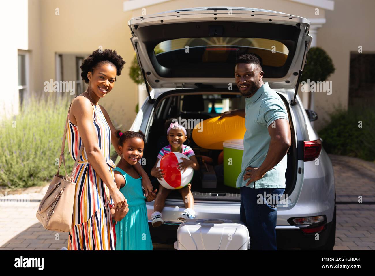 Porträt einer afroamerikanischen Familie, die lächelt, während sie in der Nähe ihres Autos steht Stockfoto