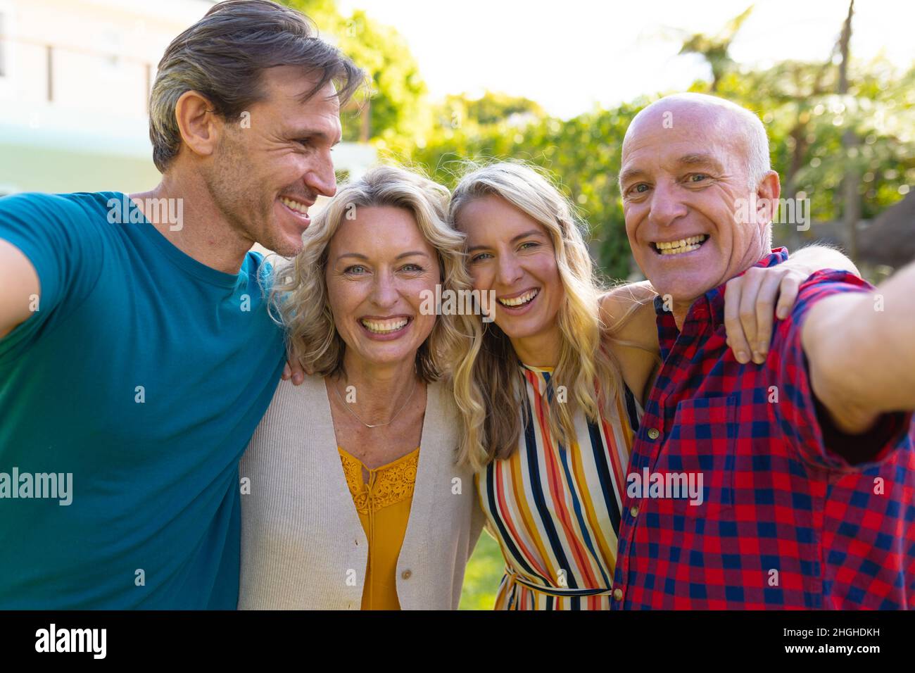 Porträt einer kaukasischen Familie der zwei Generationen, die gemeinsam im Garten Selfie gemacht hat Stockfoto