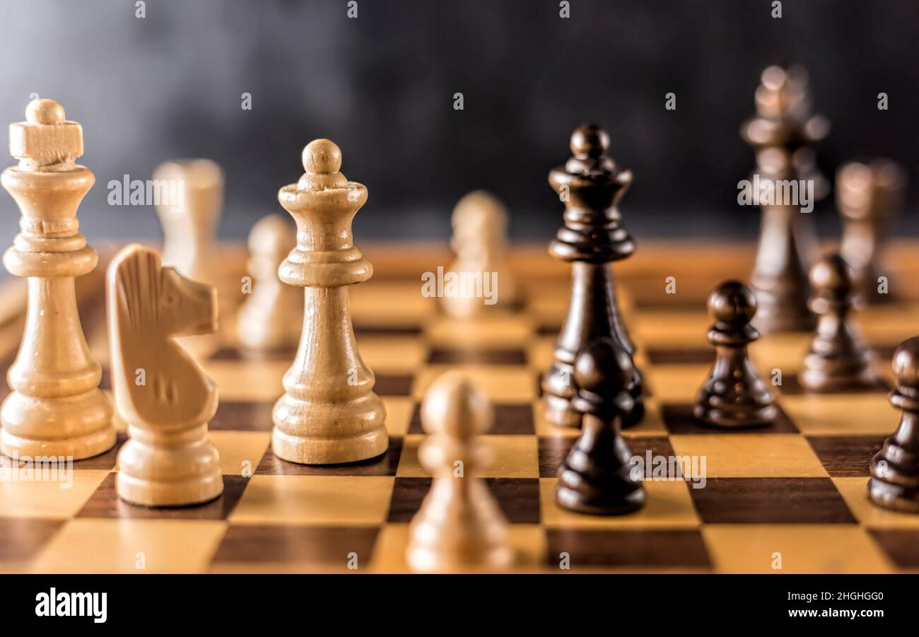 Schachbrett aus Holz mit schwarzen und weißen Königinnen, Königen, Bauern und Ritter mit neutralem Hintergrund, keine Person. Stockfoto