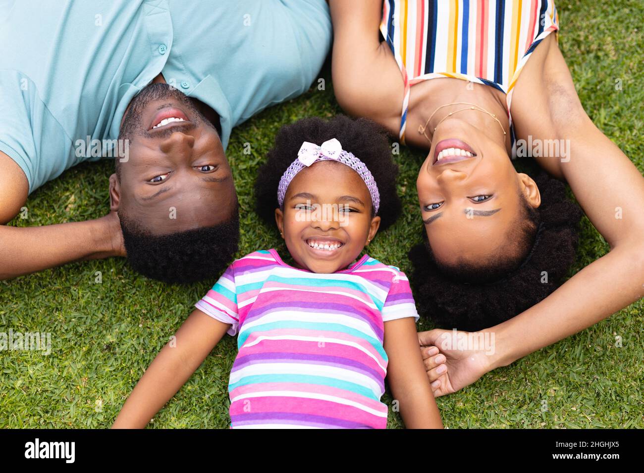 Direkt über dem Porträt einer lächelnden afroamerikanischen Familie, die auf Gras im Garten liegt Stockfoto