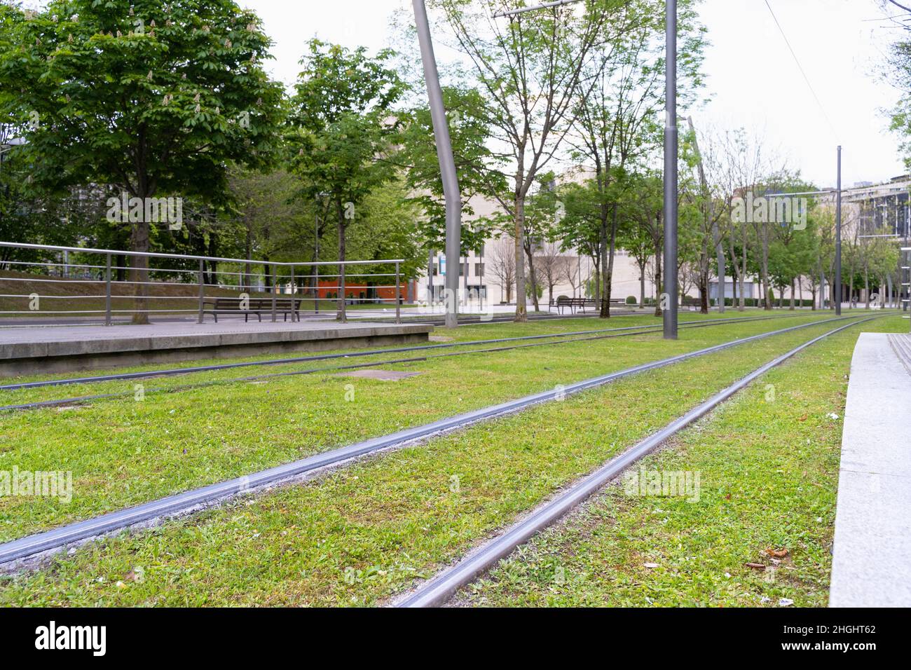Die Straßenbahn fährt am Bahnhof in Bilbao über grünes Gras. Straßenbahnschienen verschmolzen in natürliche Umgebung, niemand auf Straßenkonzepten Stockfoto