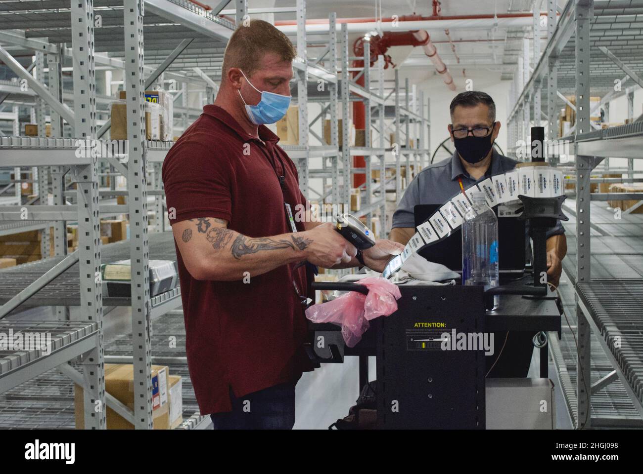 RFID-Tags werden gescannt und auf Reparaturteilen für die Luftfahrt in einem kürzlich renovierten Lagerhaus der Naval Air Station Jacksonville angebracht. Die Etiketten werden in Vorbereitung auf die Robotereinheiten platziert, die bald zur Aufrechterhaltung der Bestandsgenauigkeit verwendet werden. Stockfoto