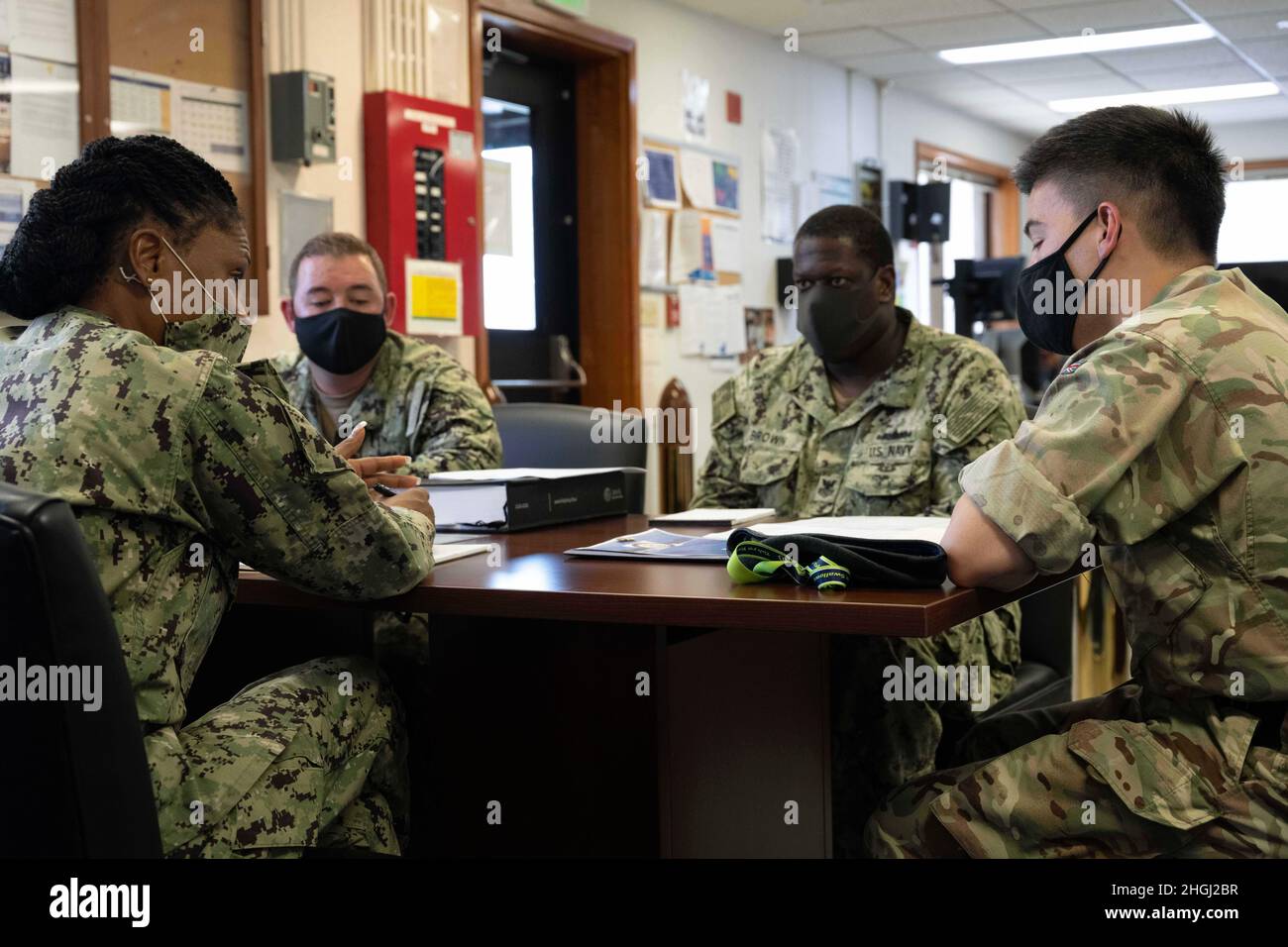 WHITE BEACH, Japan (Aug 11, 2021) British Army Maj. Kenji Ara, British Embassy Tokyo Deputy Defense Attache, rechts, trifft sich mit LT. Donna Powell, Commander, Fleet Activities Okinawa Foreign Liaison Officer, links, und dem CFAO Port Operations Department Team koordinieren und planen mögliche Besuche von britischen Schiffen in der White Beach Naval Facility. Die CFAO unterhält und betreibt Einrichtungen zur Unterstützung der Marine- und Luftfahrtanlagen der US Navy in der Indo-Pazifik-Region sowie derjenigen von Verbündeten und Partnern der Vereinten Nationen. Stockfoto