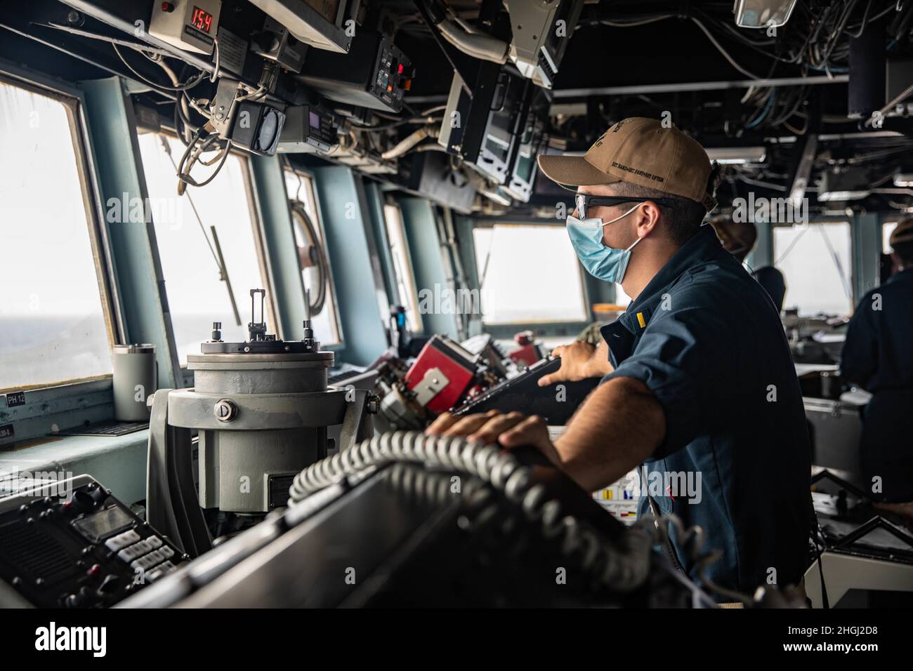 STRASSE VON HORMUS (AUG 11, 2021) – Ens. Mark Talvacchia wacht während eines Transits in der Straße von Hormuz am 11. August als der Conning Officer an Bord des Lenkraketen-Zerstörers USS Halsey (DDG 97). Halsey wird im Einsatzgebiet der 5. US-Flotte eingesetzt, um Marinestützpunkte zu unterstützen, um die maritime Stabilität und Sicherheit in der Zentralregion zu gewährleisten und das Mittelmeer und den Pazifik durch den westlichen Indischen Ozean und drei strategische Engpässe zu verbinden. Stockfoto