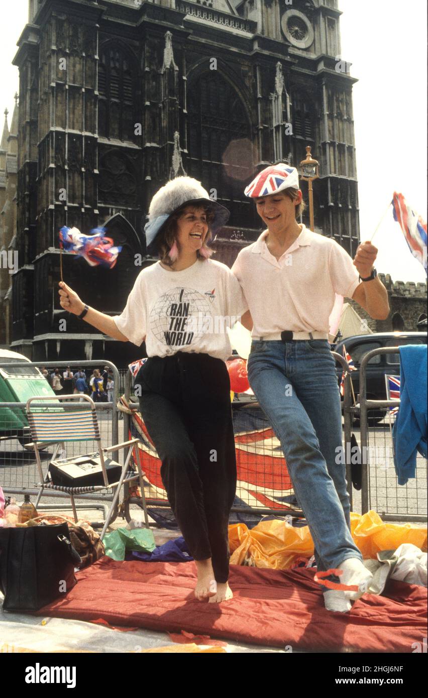 Das junge Paar streckte sich die Beine, nachdem es auf dem Bürgersteig vor der Westminster Abbey zur Hochzeit von Prinz Andrew und Sarah Ferguson am 23rd 1986. Juli geschlafen hatte Stockfoto