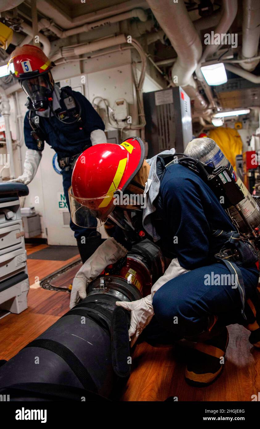 210818-N-JW440-1002 ARABISCHER GOLF (AUG 18, 2021) – Seeleute nehmen an einer Feuerbekämpfungsübung an Bord des Lenkraketen-Kreuzers USS Shiloh (CG 67) im Arabischen Golf Teil, 18. August. Shiloh wird in den Einsatzbereich der 5. US-Flotte eingesetzt, um Marineinteraktionen zu unterstützen, um die maritime Stabilität und Sicherheit in der Zentralregion zu gewährleisten und das Mittelmeer und den Pazifik durch den westlichen Indischen Ozean und drei strategische Engpässe zu verbinden. Stockfoto