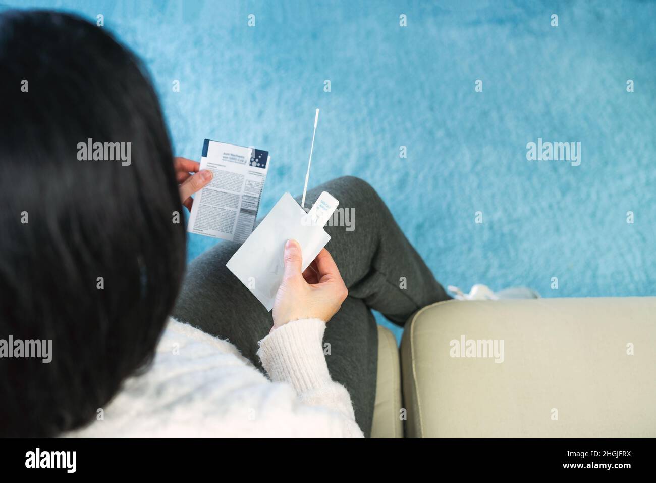 Sitzende Frau liest die Anleitung zum Antigentest für den Covid 19-Test. Speicherplatz kopieren. Coronavirus-Konzept. Stockfoto