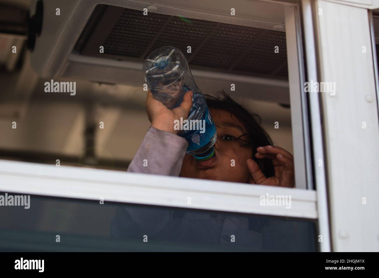 Ein afghanisches Kind trinkt Wasser in einem Bus während einer nicht kämpferischen Evakuierungsoperation auf dem Ali Al Salem Airbase, Kuwait, 23. August 2021. Stockfoto