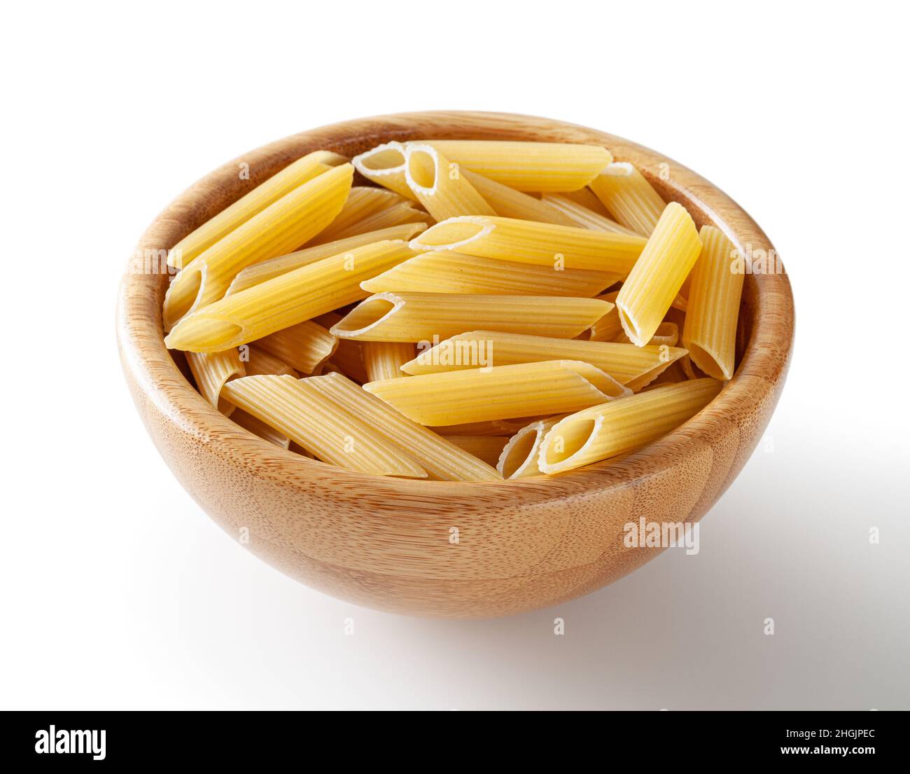 Ungekochte Penne-Pasta in Holzschüssel isoliert auf weißem Hintergrund mit Schneideweg Stockfoto