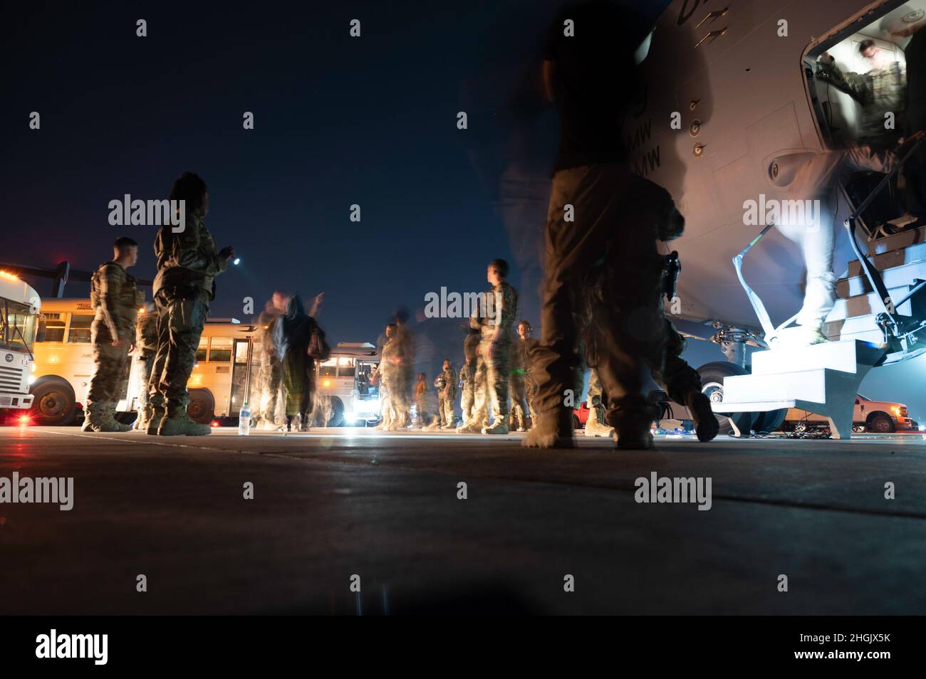 Mitglieder der 386th Expitionary Security Forces Squadron begleiten evakuierte Afghanistans, nachdem sie mit einem C-17 Globemaster III-Flugzeug auf der Ali Al Salem Air Base, Kuwait, am 24. August 2021 angekommen sind. Das Verteidigungsministerium hat sich verpflichtet, die Evakuierung von amerikanischen Bürgern, Antragstellern für besondere Einwanderungsvisa und anderen gefährdeten Personen aus Afghanistan zu unterstützen. Stockfoto