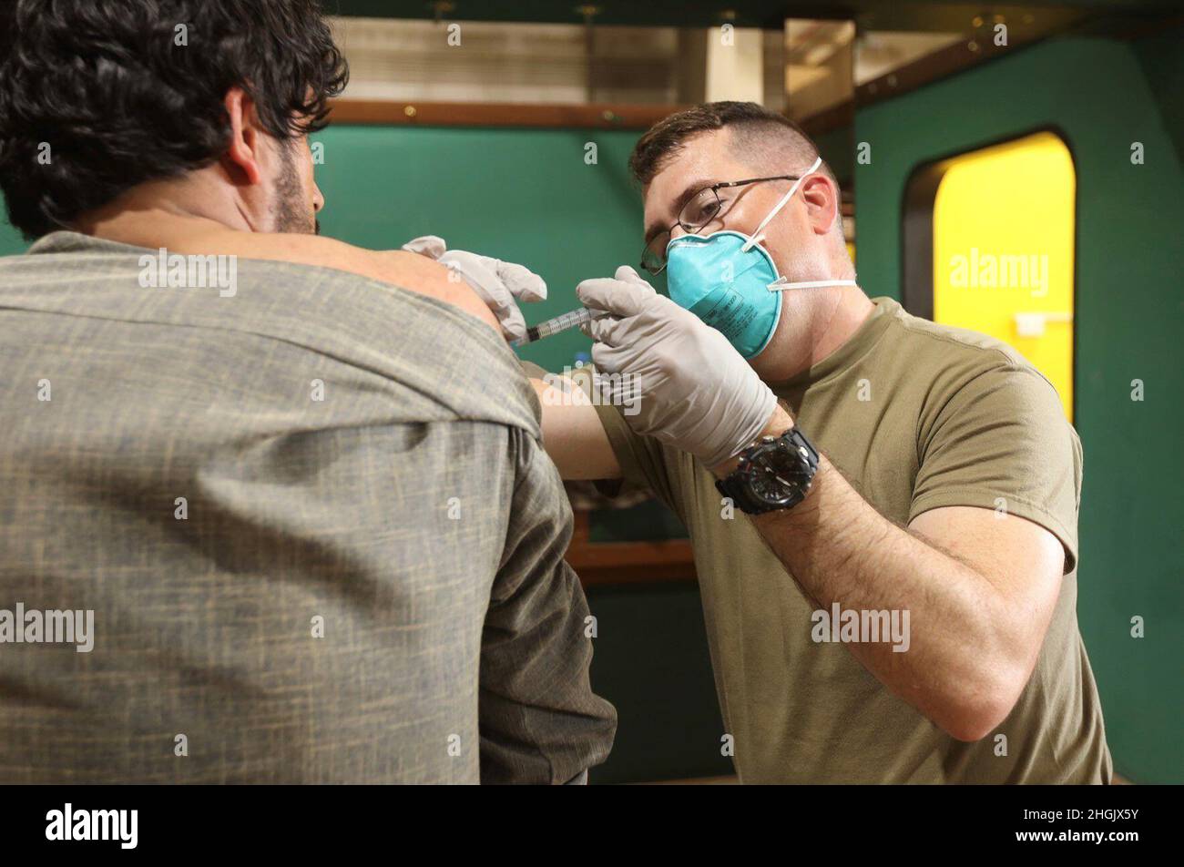 US Army Sgt. 1st Klasse Joseph Binan, ein Gesundheitsspezialist bei der 501st Medical Company Area Support, verabreicht einen Impfstoff gegen COVID-19 an einen afghanischen Evakuierten im Camp in Sayliyah, Katar, 24. August 2021. Soldaten unterstützen weiterhin die Evakuierungsbemühungen des Verteidigungsministeriums und des Außenministeriums in Afghanistan mit Sorgfalt und Mitgefühl an verschiedenen Standorten des US-Zentralkommandos. Stockfoto