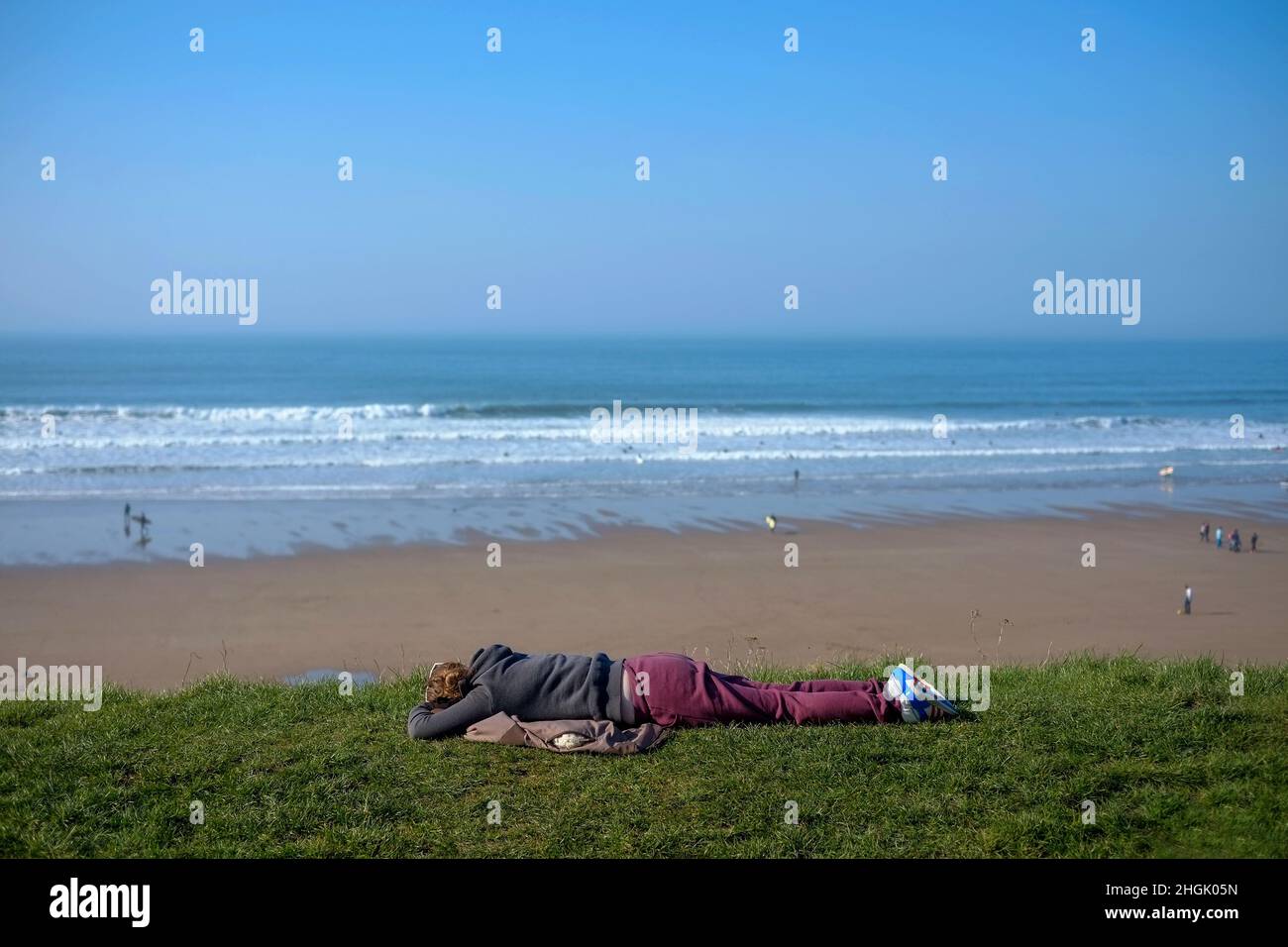 Surfer beobachten die Wellen mit Blick auf den Strand in Putsborough, North Devon, Stockfoto