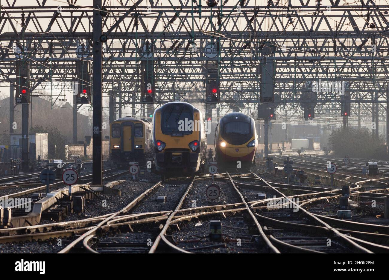 Northern Rail, Crosscountry und Virgin Züge, die mit roten Signalen an der geschäftigen Manchester Piccadilly Station Throat fahren Stockfoto