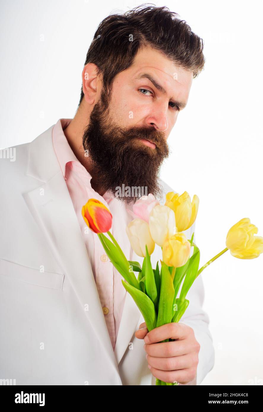 Geschäftsmann mit Tulpenstrauß. Bärtiger Mann mit Blumen. Valentinstag, Frauentag, Geburtstag. Stockfoto