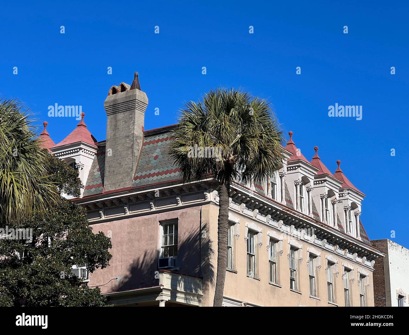 Nahaufnahme von Schieferschindeln, detailreichen Giebeln auf einem Mansardendach und Gebißverzierungen im historischen Charleston, South Carolina. Stockfoto