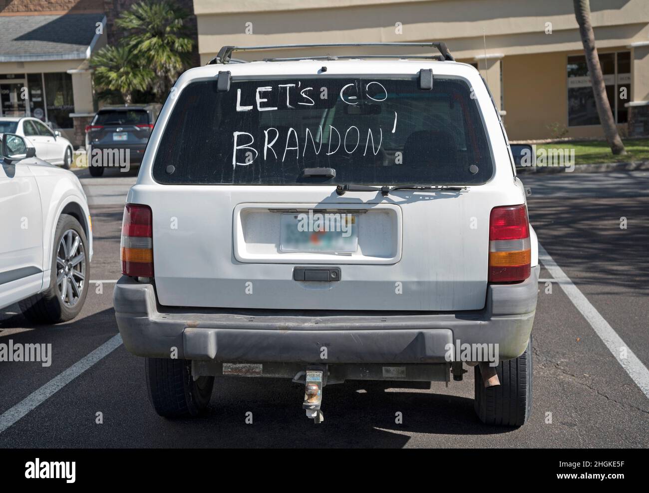 Let's Go Brandon-Schriftzug und Kamala-Schwalben auf den Vorder- und Seitenscheiben eines Fahrzeugs auf dem Parkplatz in Gainesville, Florida. Stockfoto