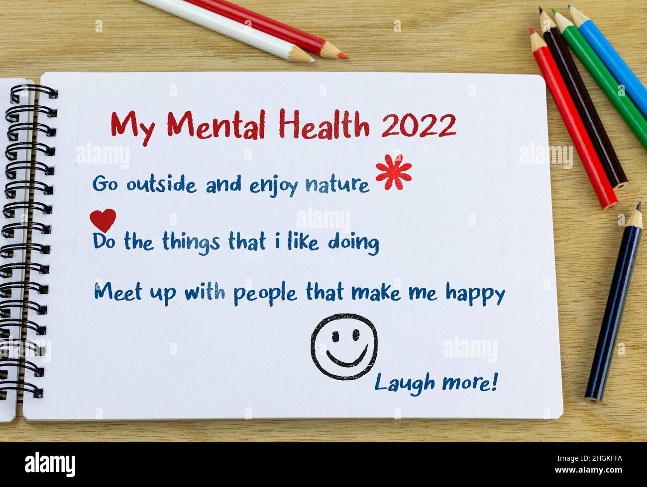 Ziele für psychische Gesundheit 2022 Überschrift mit einer Liste von Ideen, die in einem Notizbuch auf dem Schreibtisch handgeschrieben sind. Konzept der Wohlfühlziele für das neue Jahr. Stockfoto