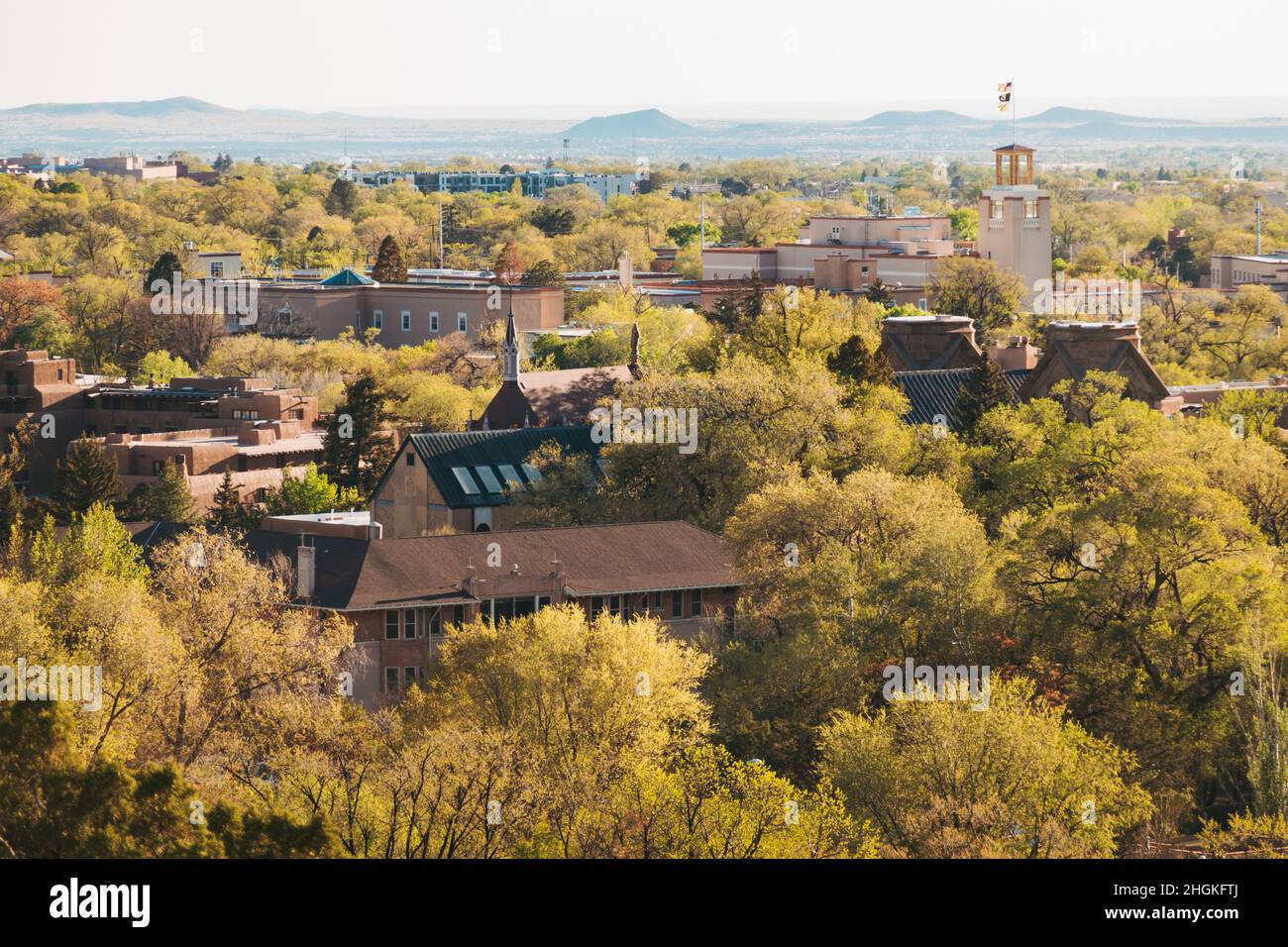 Ein Blick auf die Altstadt von Santa Fe, New Mexico, mit ihren Holz- und lehmbauten, die über die zahlreichen grünen Bäume blicken Stockfoto